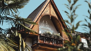 A traditional wooden building with a triangular roof and decorative wooden balconies. - Hotel Villa Freiheim (Merano)