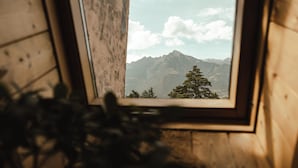 A window with a view of a mountain range and a tree. - Hotel Villa Freiheim (Merano)