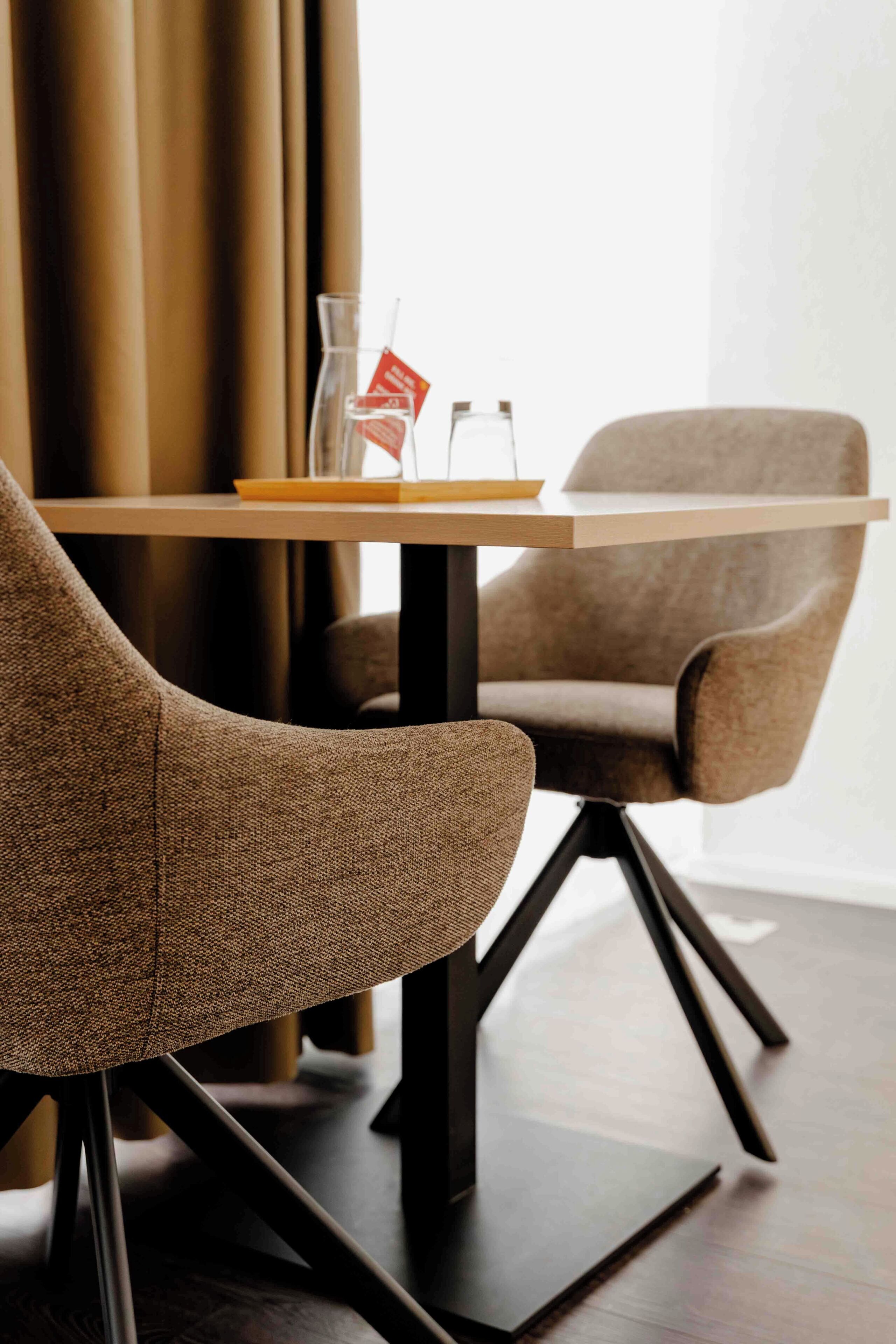 Ein modernes Zimmer mit einem Holztisch und zwei Polsterstühlen.