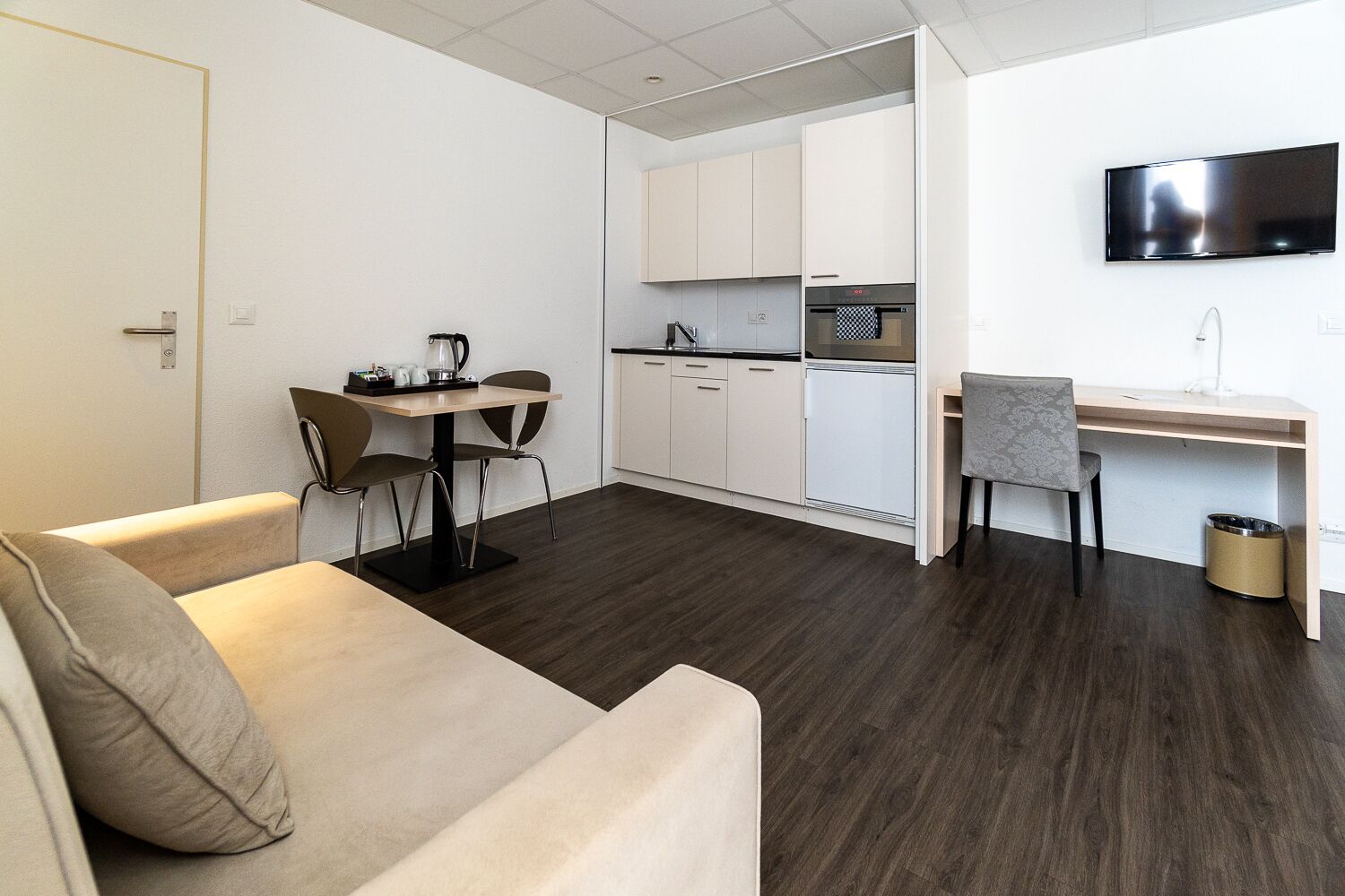 A compact living space with a kitchenette, a dining area, and a seating area.
