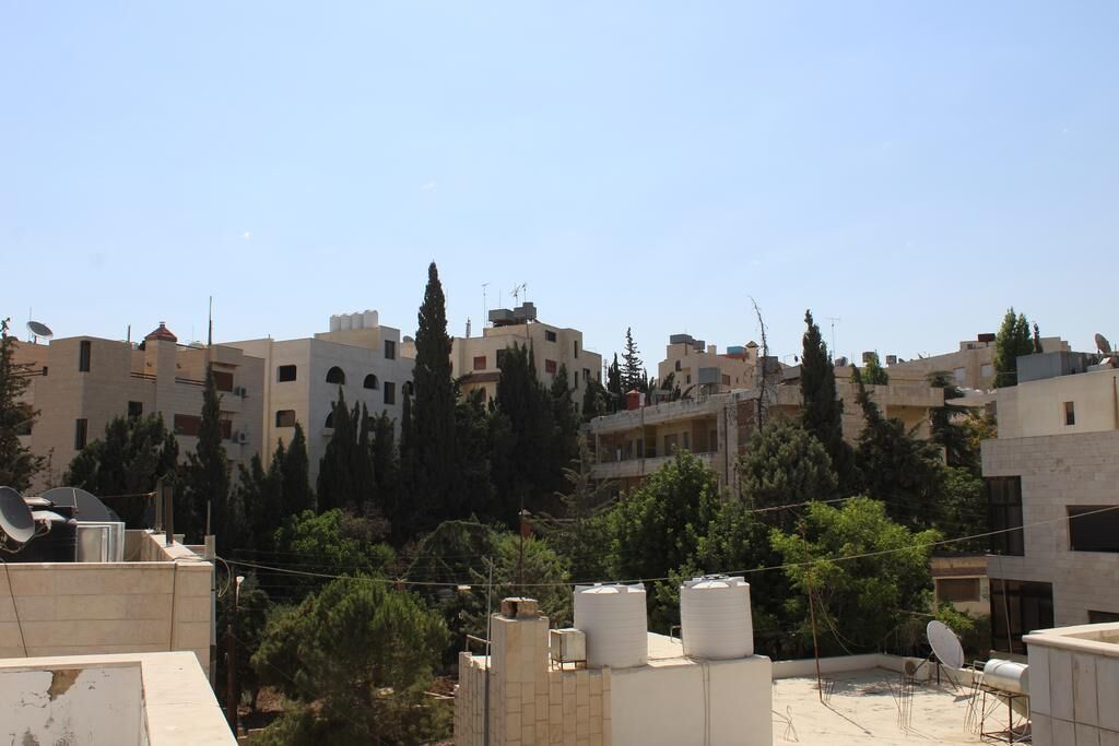 Zona residencial con varios edificios de apartamentos, antenas parabólicas y depósitos de agua en los tejados.