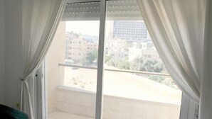 Ein Balkon mit Blick auf Gebäude und einen klaren Himmel.