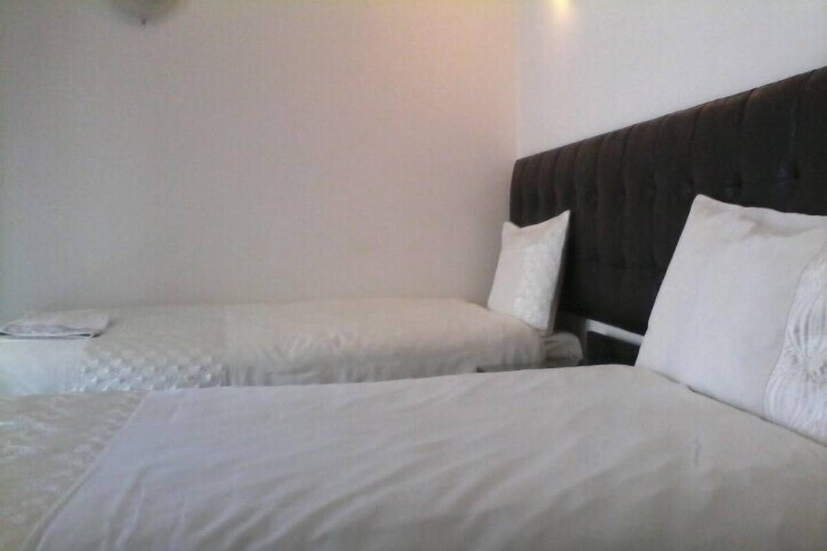 A hotel room with two beds, each with white bedding and pillows.