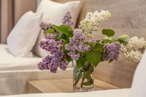 A clear view of a room with a bed, a nightstand, and a vase with flowers.