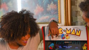 Una persona jugando un videojuego en una máquina de videojuegos antigua.