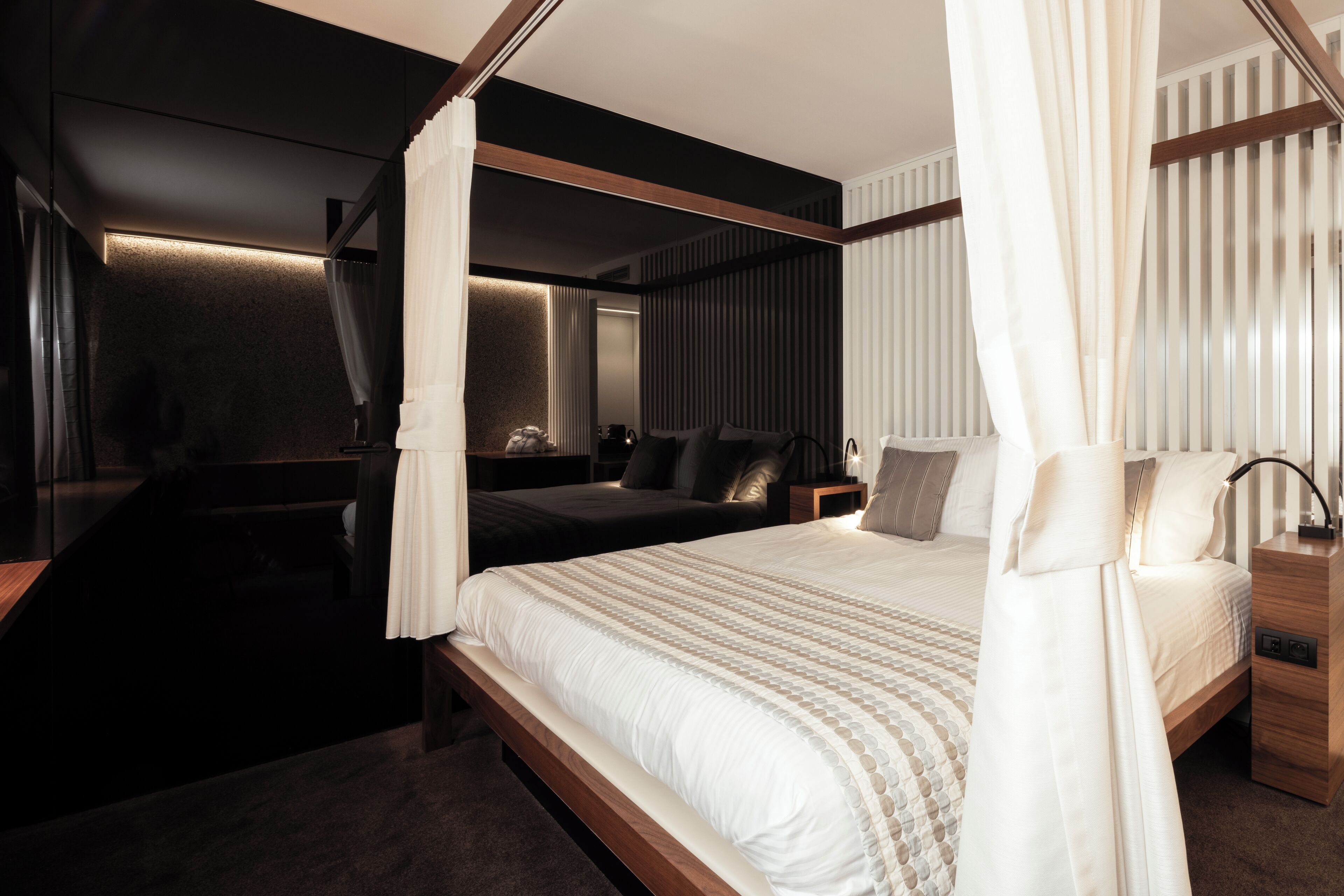 Un dormitorio moderno con una cama grande, una mesita de noche y un dosel.