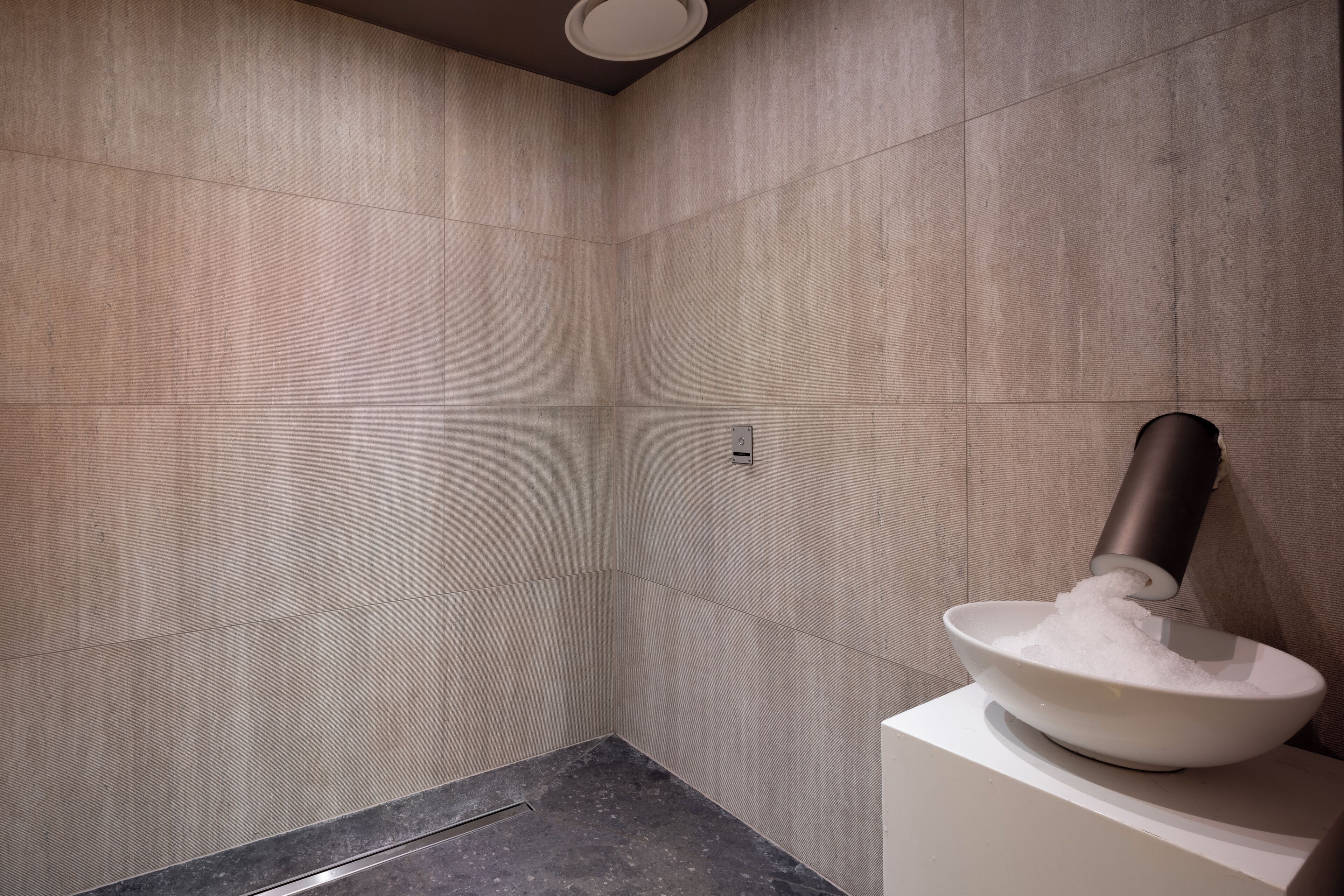 Une salle de bain moderne avec un grand lavabo et un robinet mural.