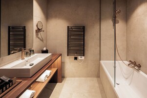 A modern bathroom with a large sink, wooden vanity, and a separate shower area.