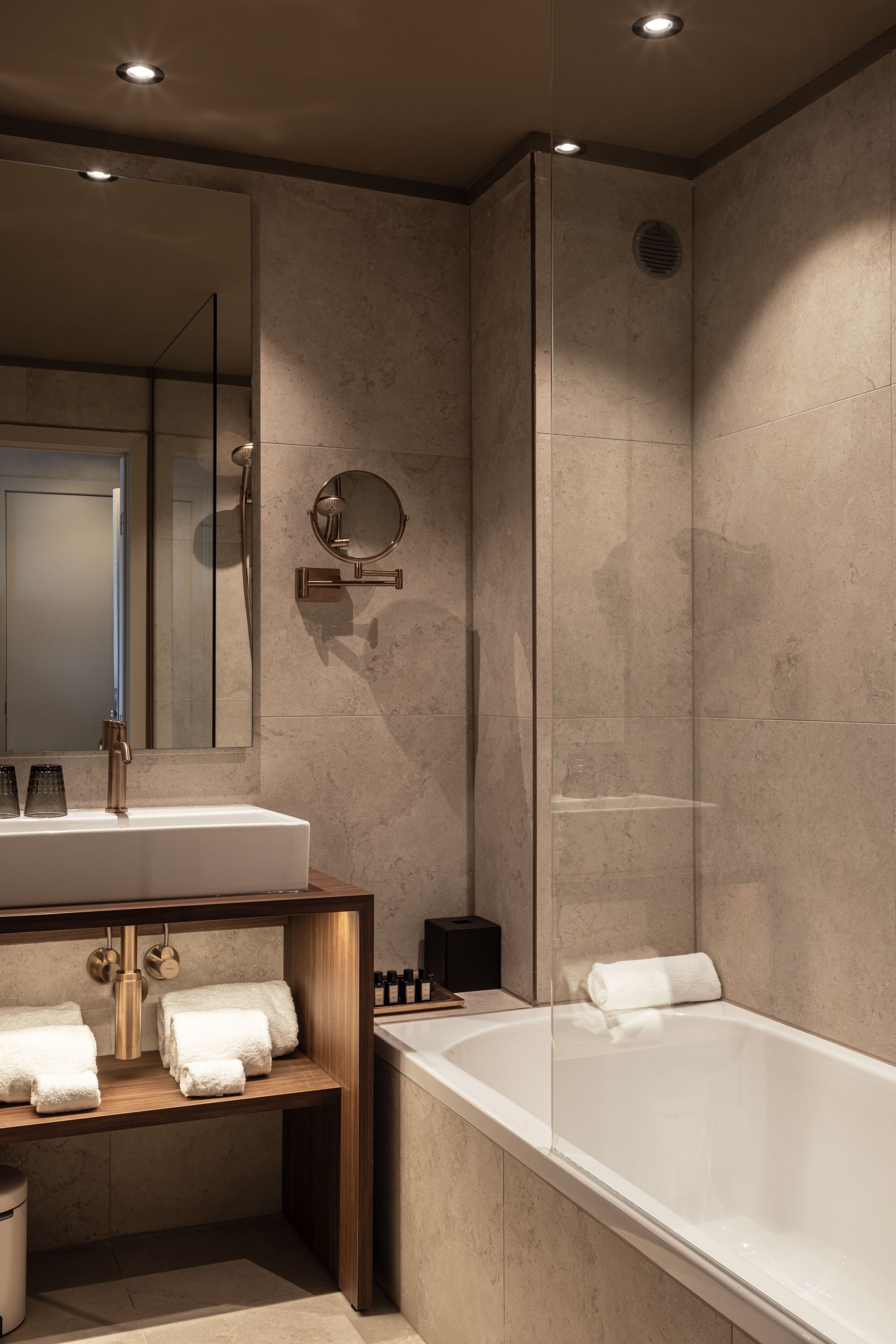 A modern bathroom with a large mirror, a bathtub, and a shower area.