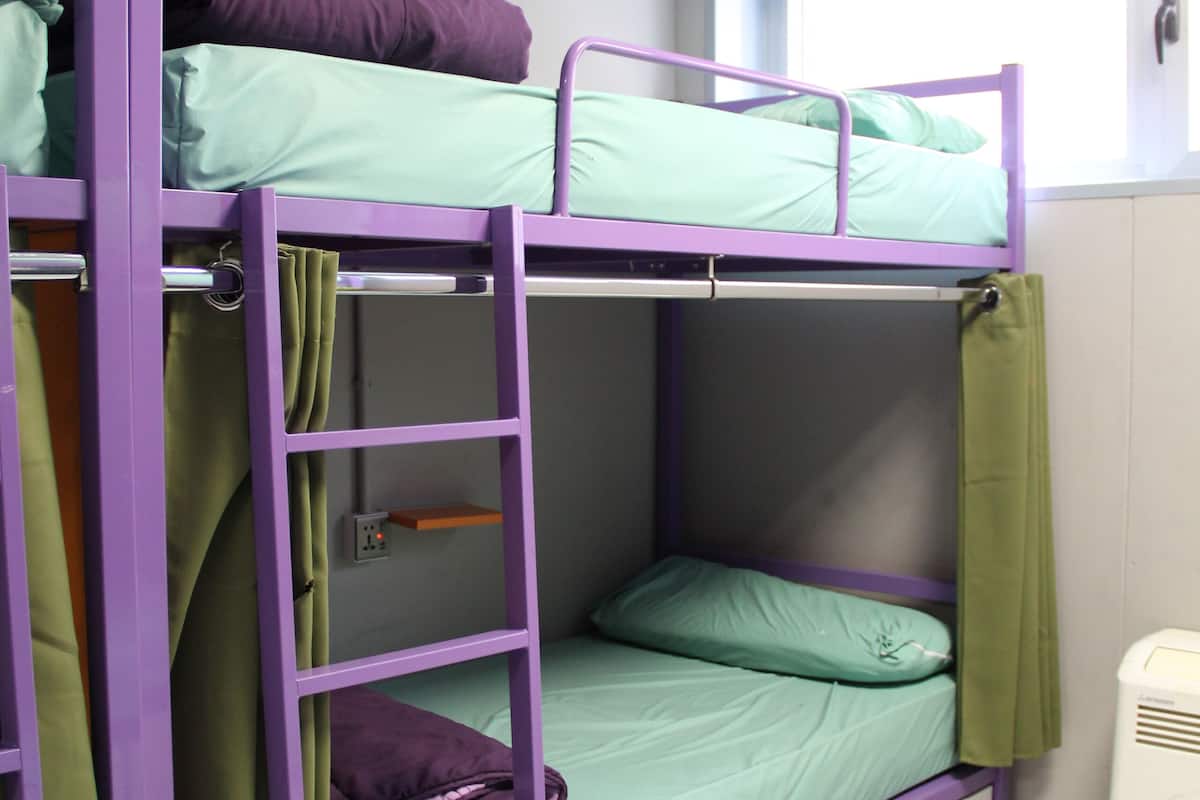 High bed in a 12-bed mixed dormitory with shared bathroom