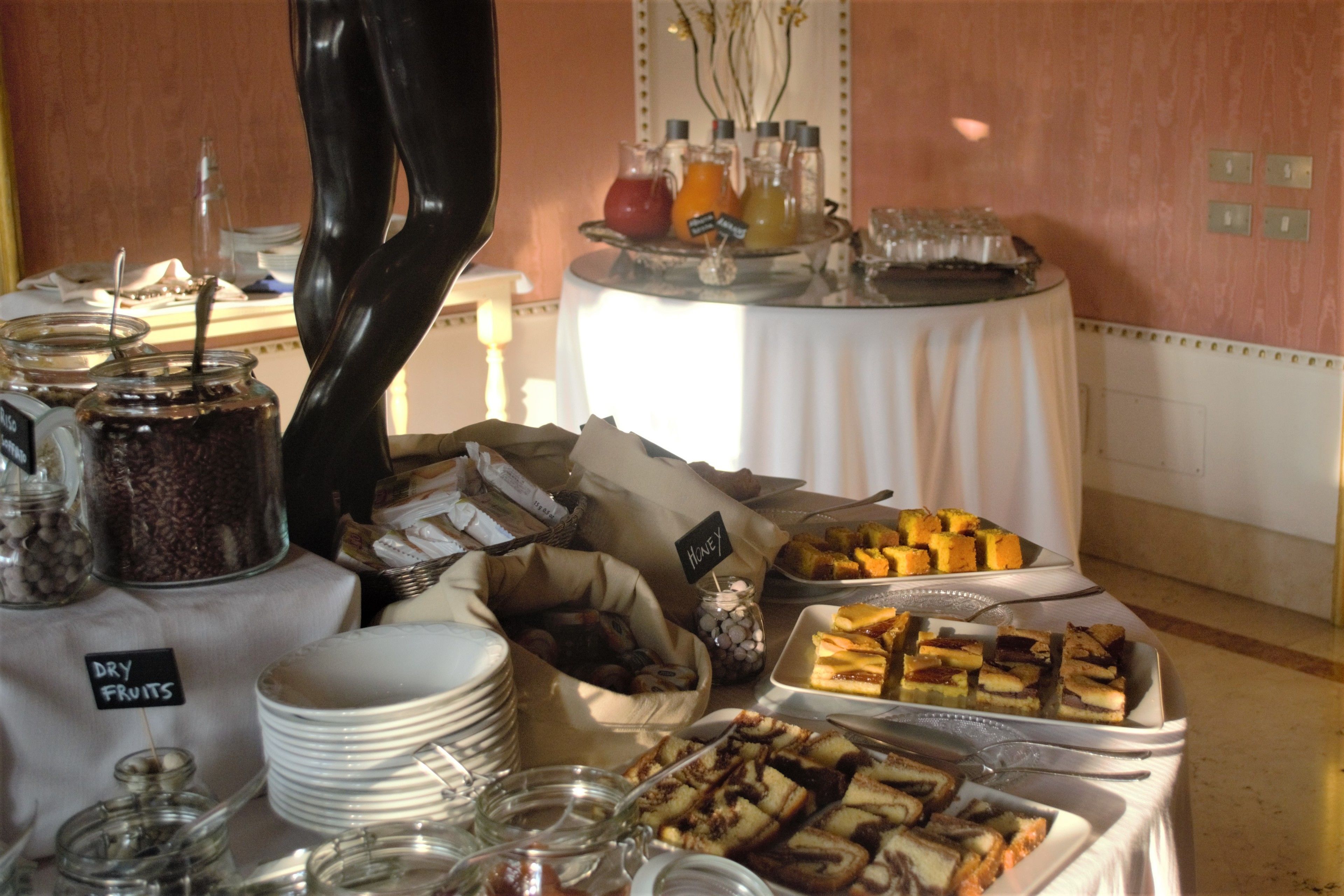 Una mesa de buffet con diversos alimentos, como frutas, pasteles y bebidas.