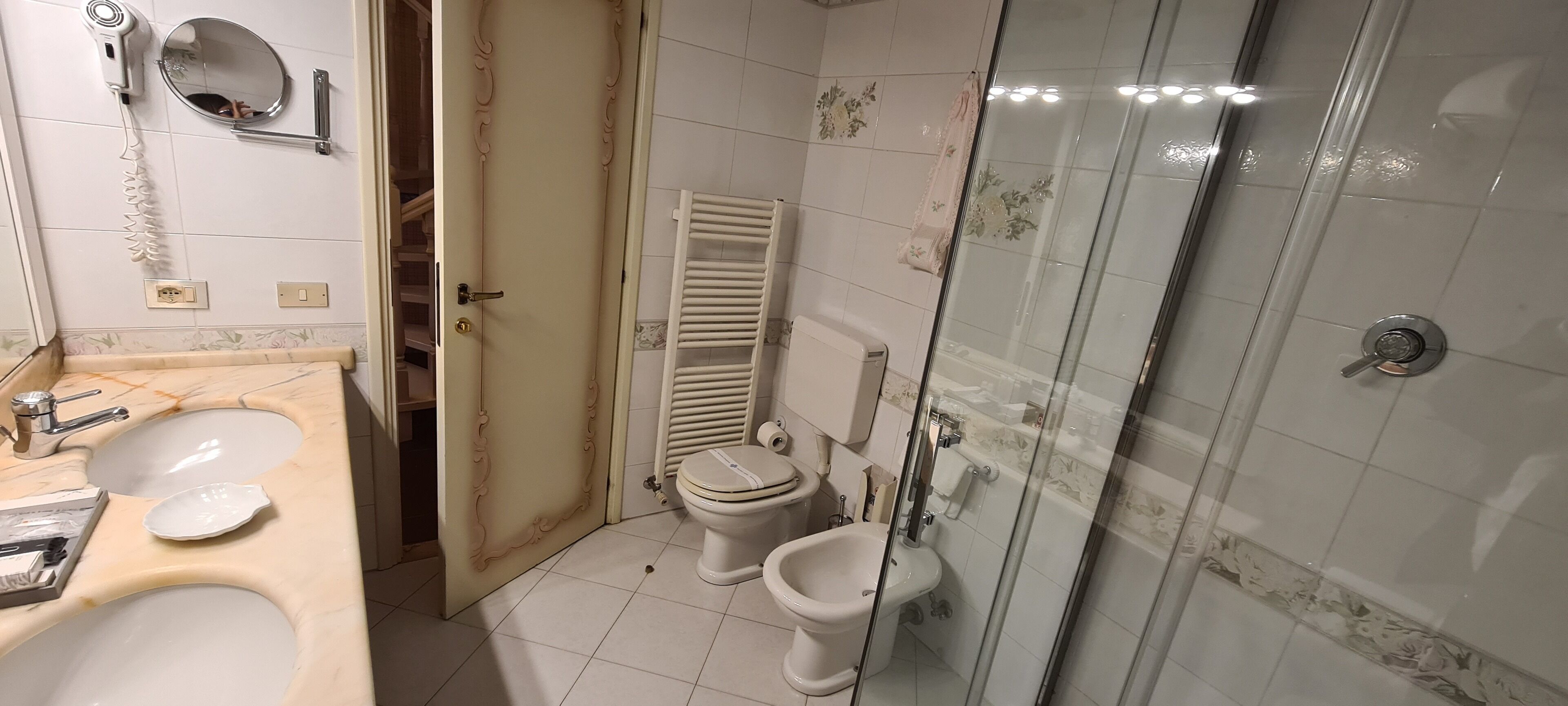 Ein Badezimmer mit Waschbecken, Toilette, Bidet und Duschkabine.