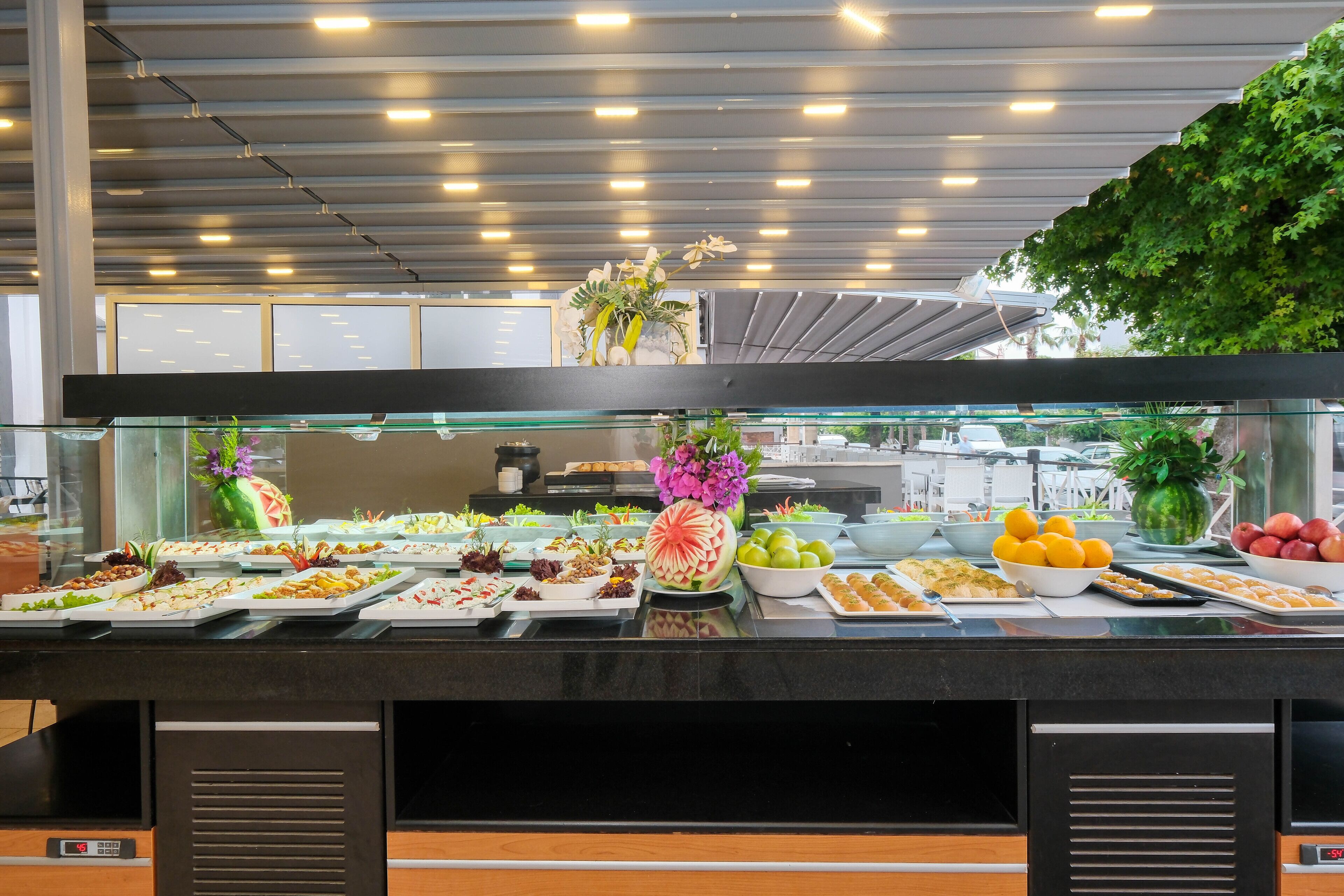 A buffet with various food items and a decorative centerpiece.