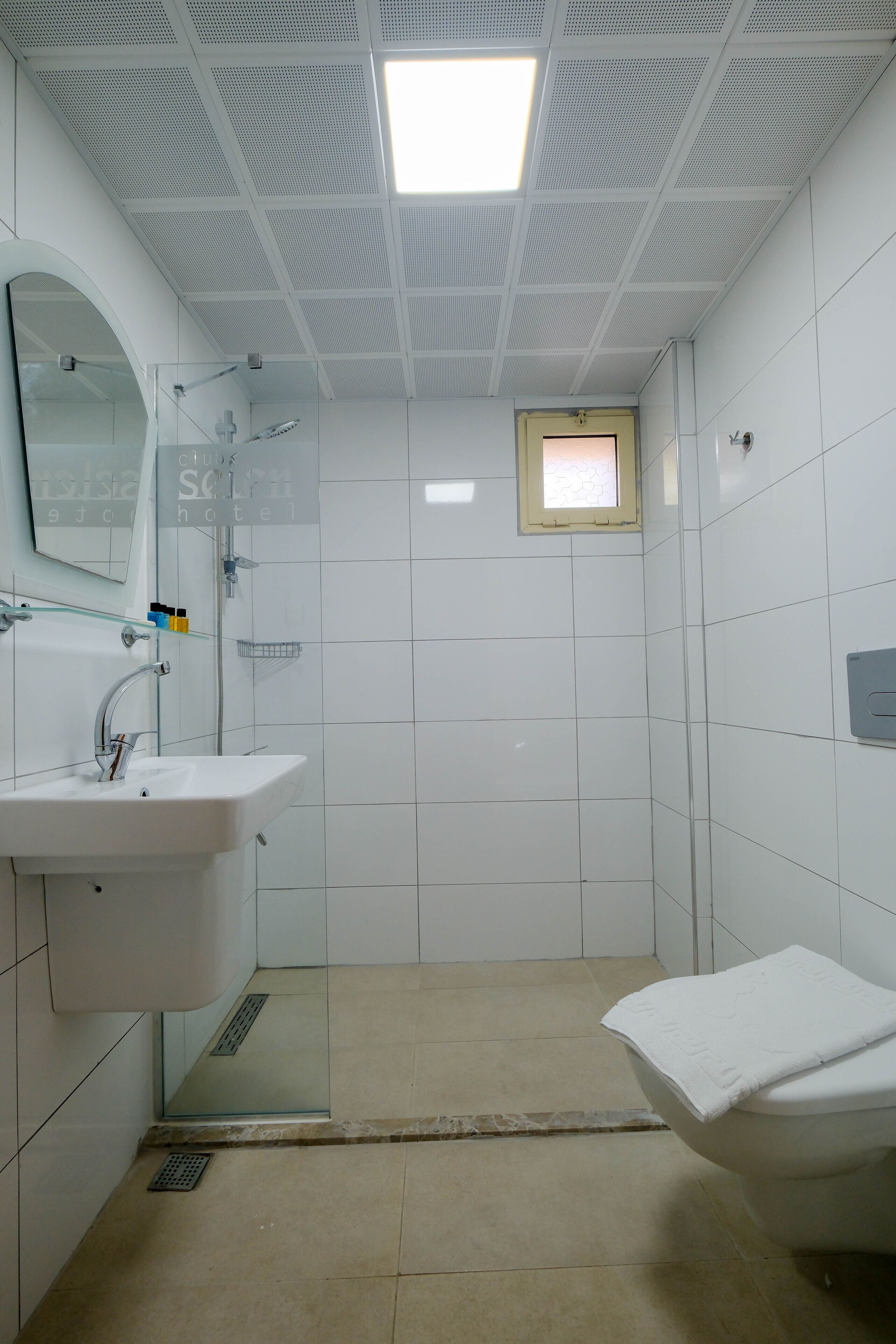A bathroom with a white sink, a glass shower enclosure, and a toilet.