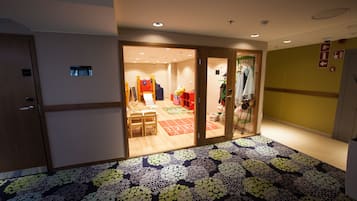 Welcome to our lobby, featuring a patterned carpet and a reception desk with a chair and table.