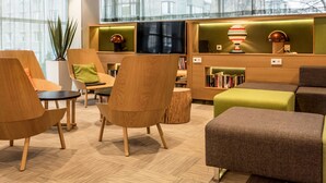 Un área de estar moderna con muebles de madera, un televisor y estanterías.
