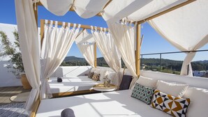 Camera sul tetto con vista sul paesaggio, un letto con cuscini e un tavolino con vassoio.
