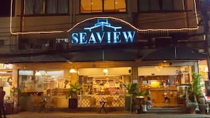 A restaurant named "Seaview" with outdoor seating and a visible menu board. - Seaview Sriracha Hotel (Si Racha)