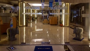 A modern hotel lobby with a 'WELCOME' sign, seating area, and a reception desk. - Seaview Sriracha Hotel (Si Racha)