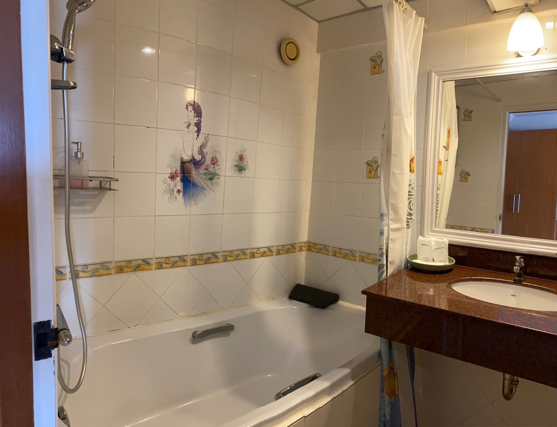 A bathroom with a bathtub, a shower, a sink, and a mirror.