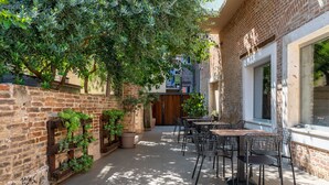 A patio with outdoor seating, brick walls, and potted plants. - Azur Palace Luxury Rooms (Split)