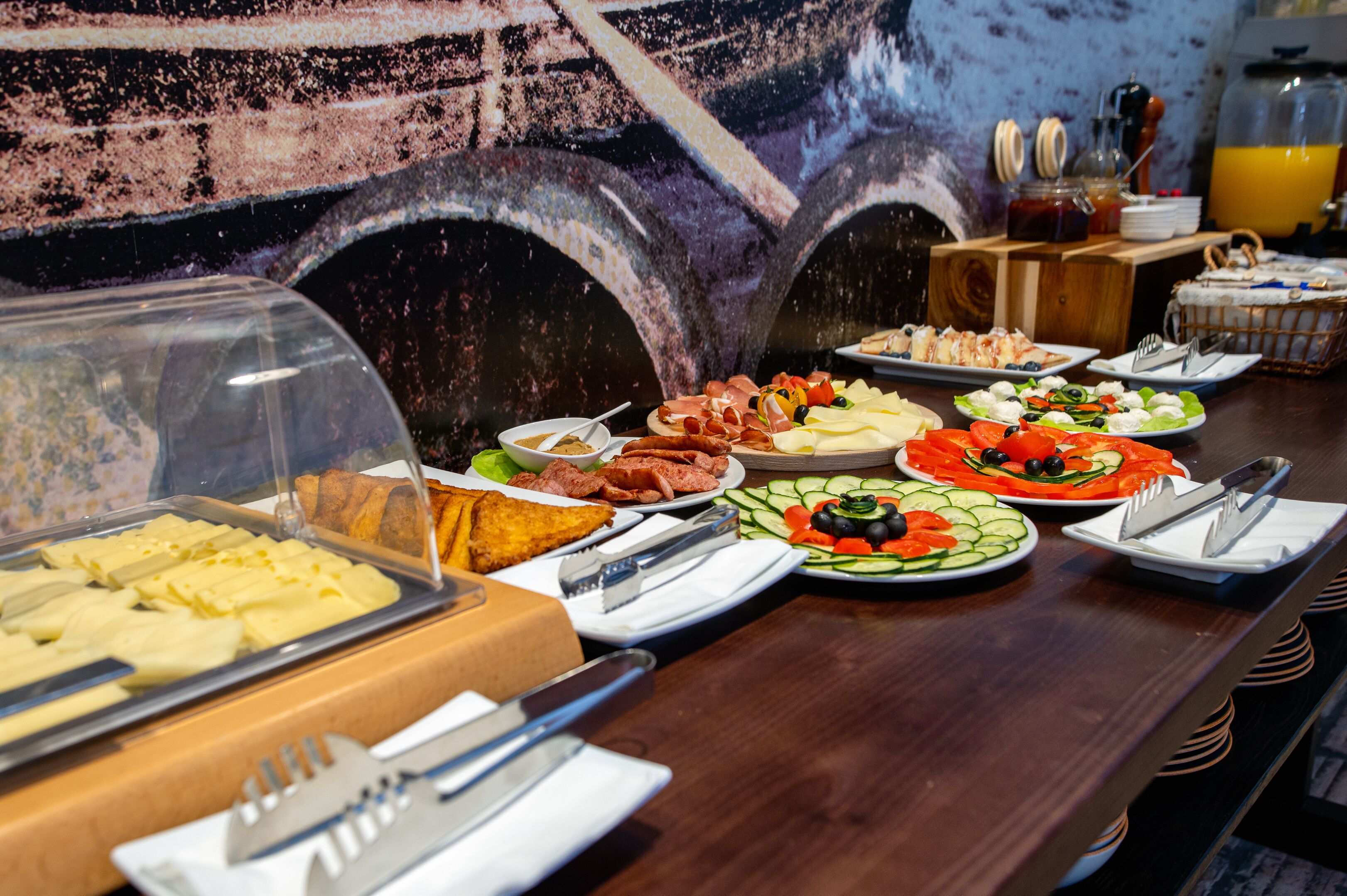 Un buffet proposant une variété de plats et un distributeur de jus.