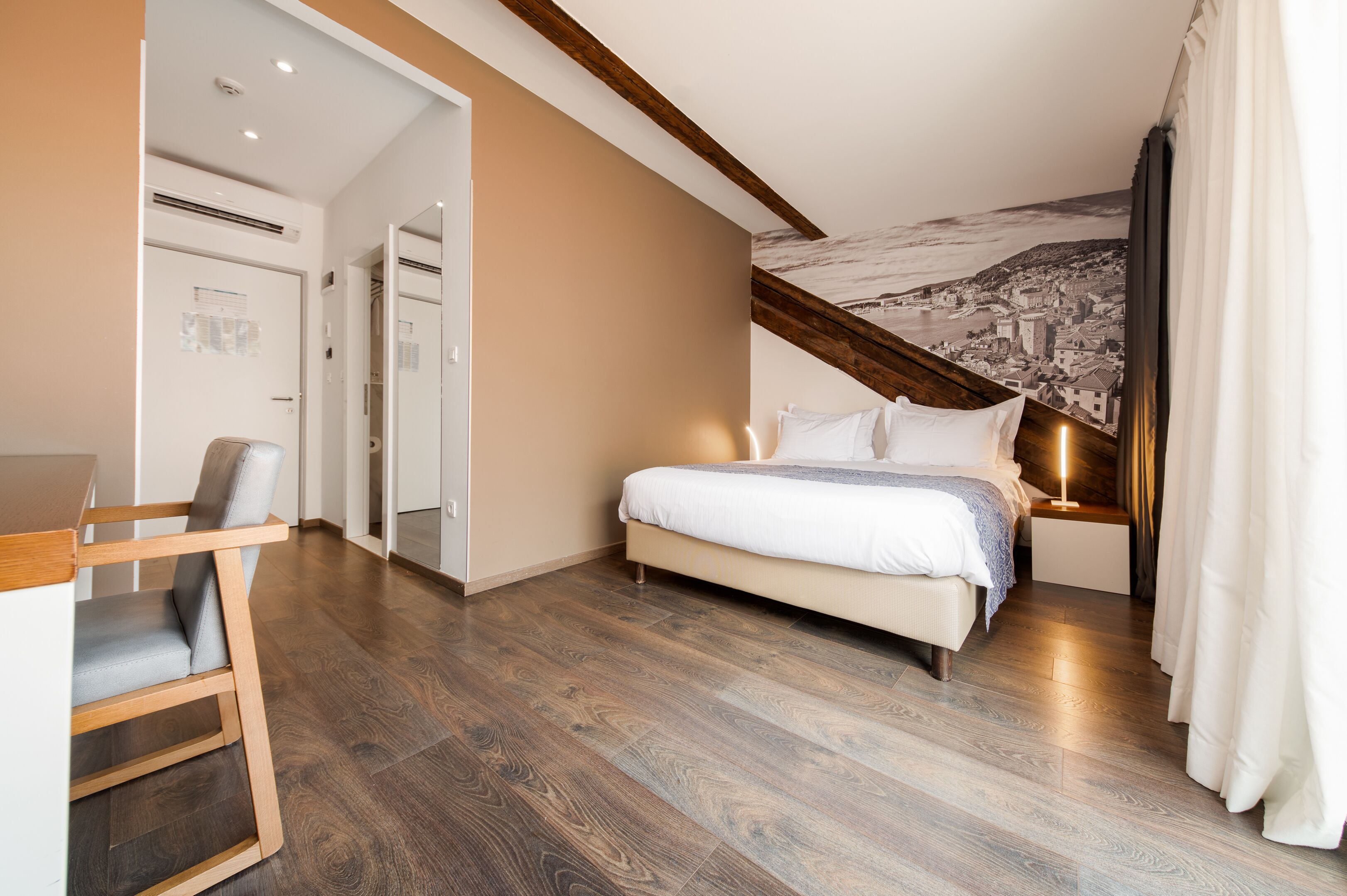 A bedroom with a bed, a chair, and a nightstand.