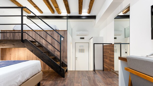 A modern interior with a bunk bed, wooden flooring, a staircase, and a kitchenette. - Azur Palace Luxury Rooms (Split)