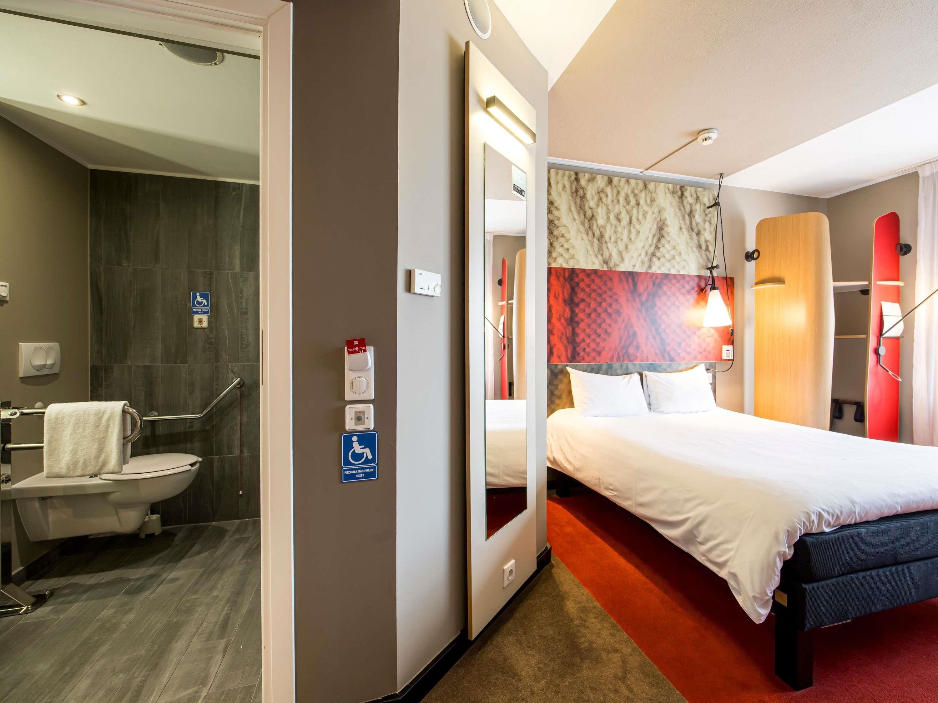 A hotel room with a bathroom, a bed, and a shower area.