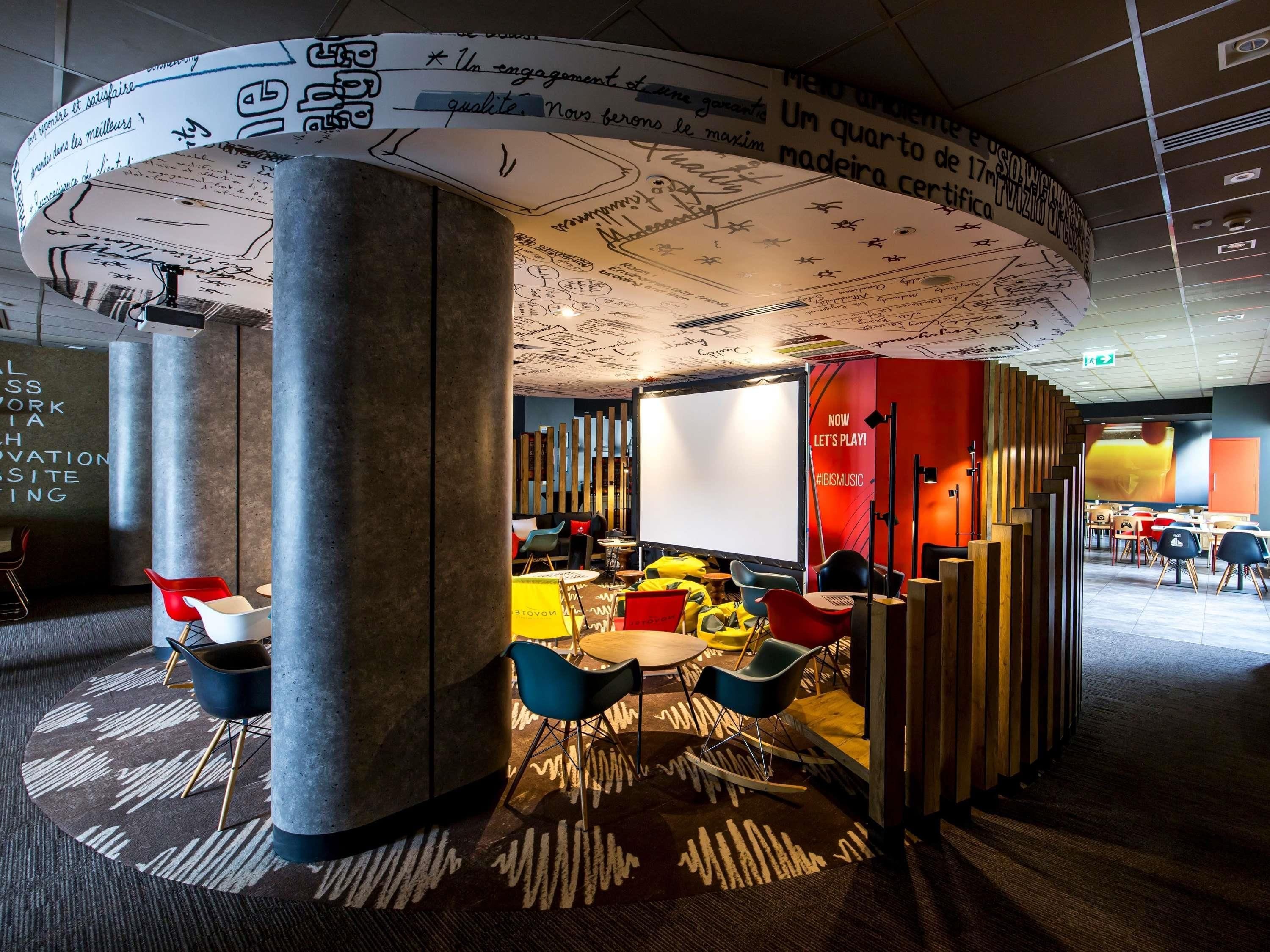 A modern interior with a circular design element, seating arrangements, and a visible wall with text.