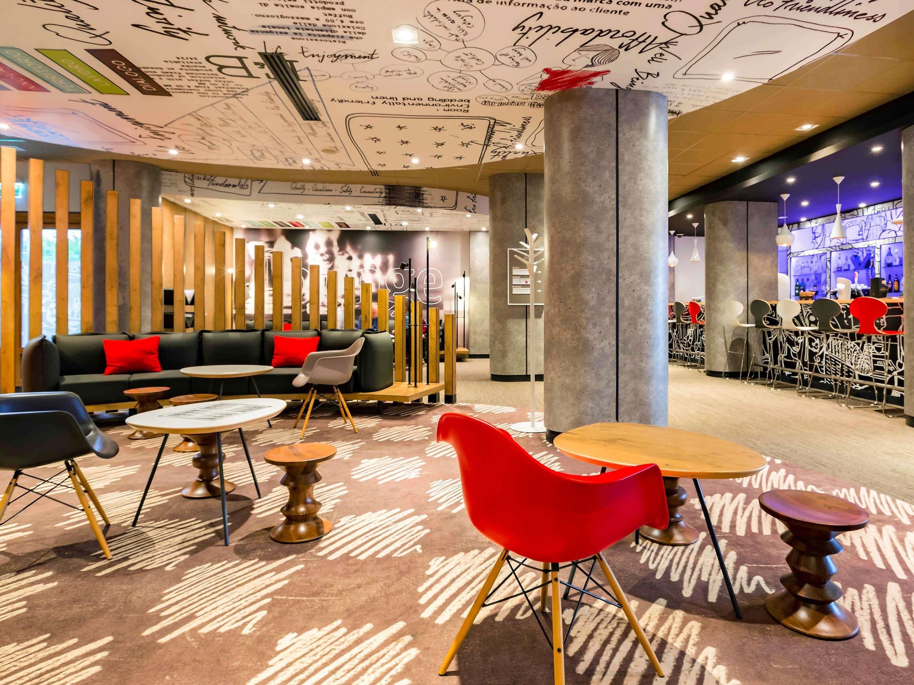 Un espace de détente moderne comprenant un canapé, des fauteuils, des tables et un bar.