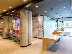 A modern reception area with a reception desk, seating, and a mural wall.