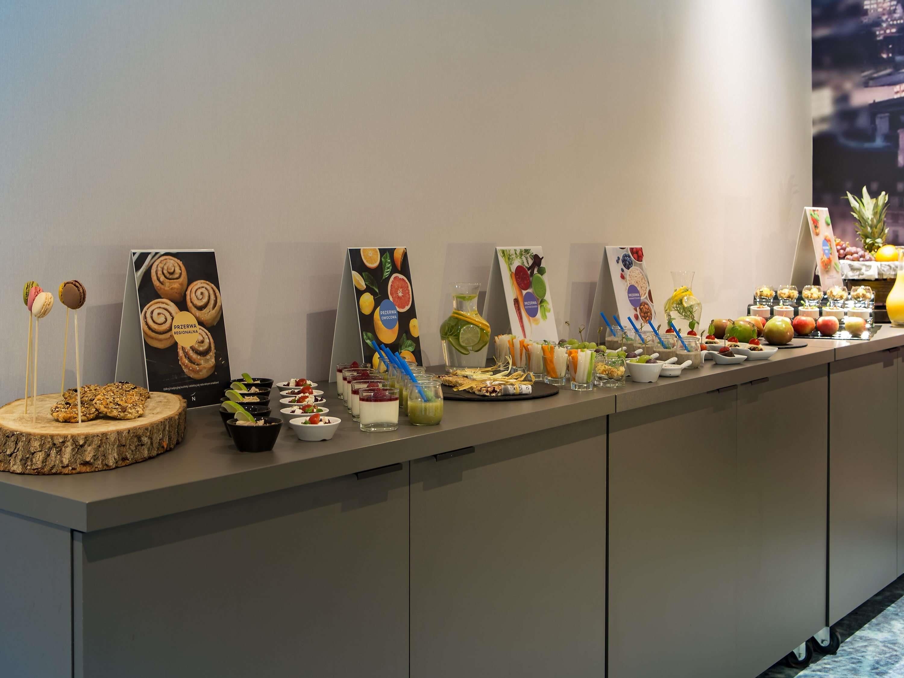 Un bufé con diversos alimentos y un cartel.