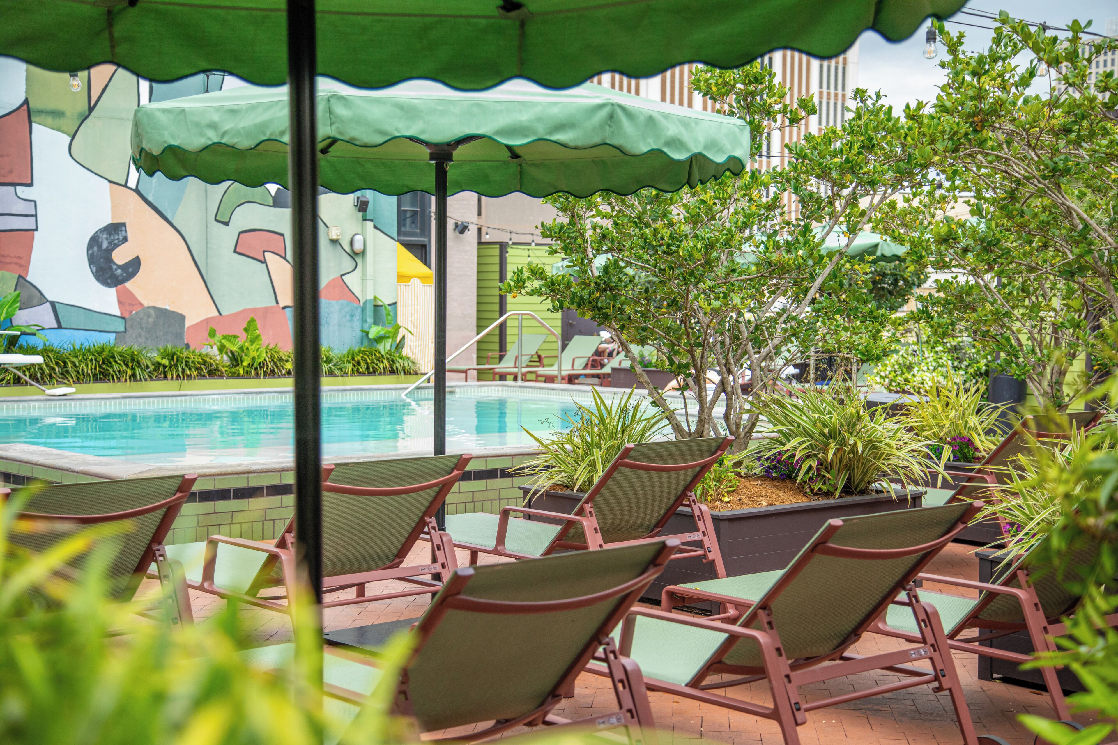 A poolside area with lounge chairs and a mural.