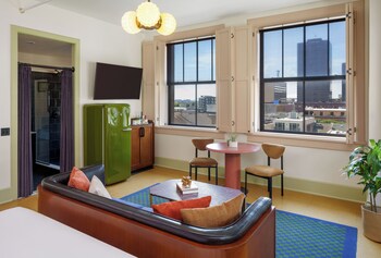 A café with wooden tables and chairs, a coffee bar, and a refrigerator. at The Barnett - JDV by Hyatt