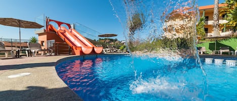 Una piscina al aire libre de temporada, sombrillas