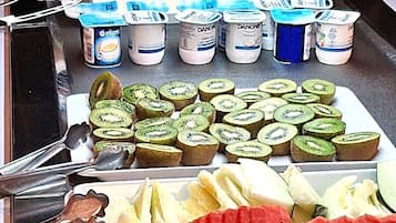 A buffet with sliced fruits and dairy products.