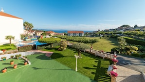 A hotel with a pool, green lawns, and a view of the sea. - Hotel Atlántico Sanxenxo (Sanxenxo)