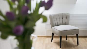 A chair with a checkered pattern, a white wall, and a wooden floor.