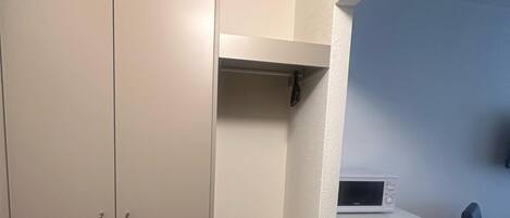 A small, enclosed room with a kitchenette area, a desk, and a chair.