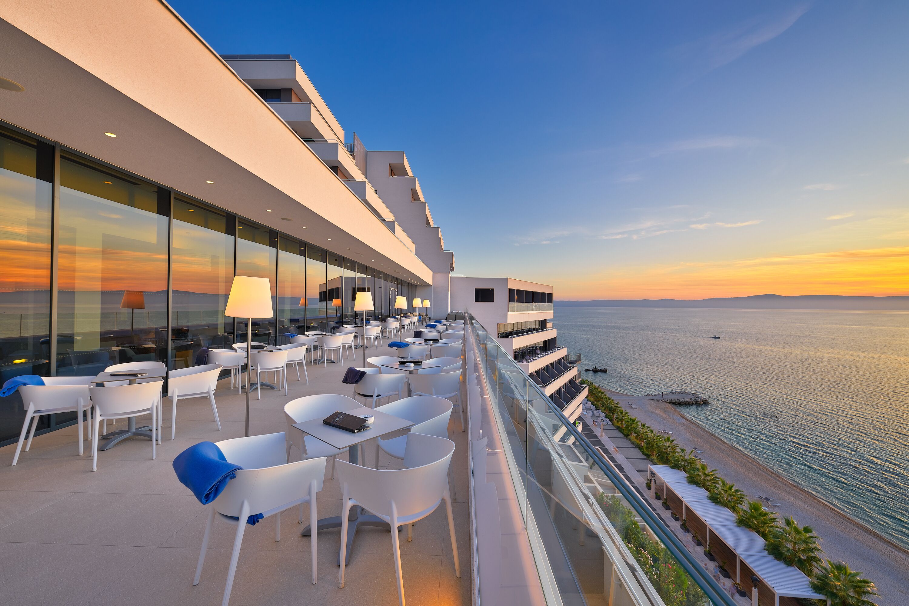 A rooftop terrace with outdoor seating and a view of the sea.