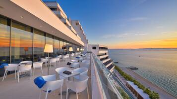 A rooftop terrace with outdoor seating and a view of the sea.