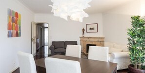 Un salon moderne avec une cheminée, des meubles blancs et un grand tableau accroché au mur.