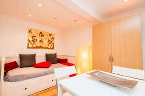 A bedroom with a bed, a desk, and a wardrobe.