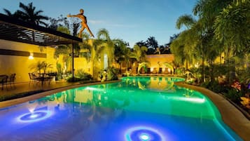 Una piscina al aire libre, sillones reclinables de piscina