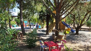 Un parque infantil con tobogán, columpios y una estructura para escalar.