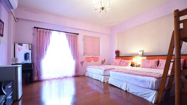 A bedroom with two beds, a desk, and a chair. - The Garden Rose B&B (Taitung)