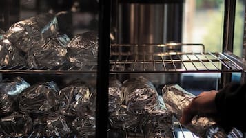 An oven with food items wrapped in aluminum foil.