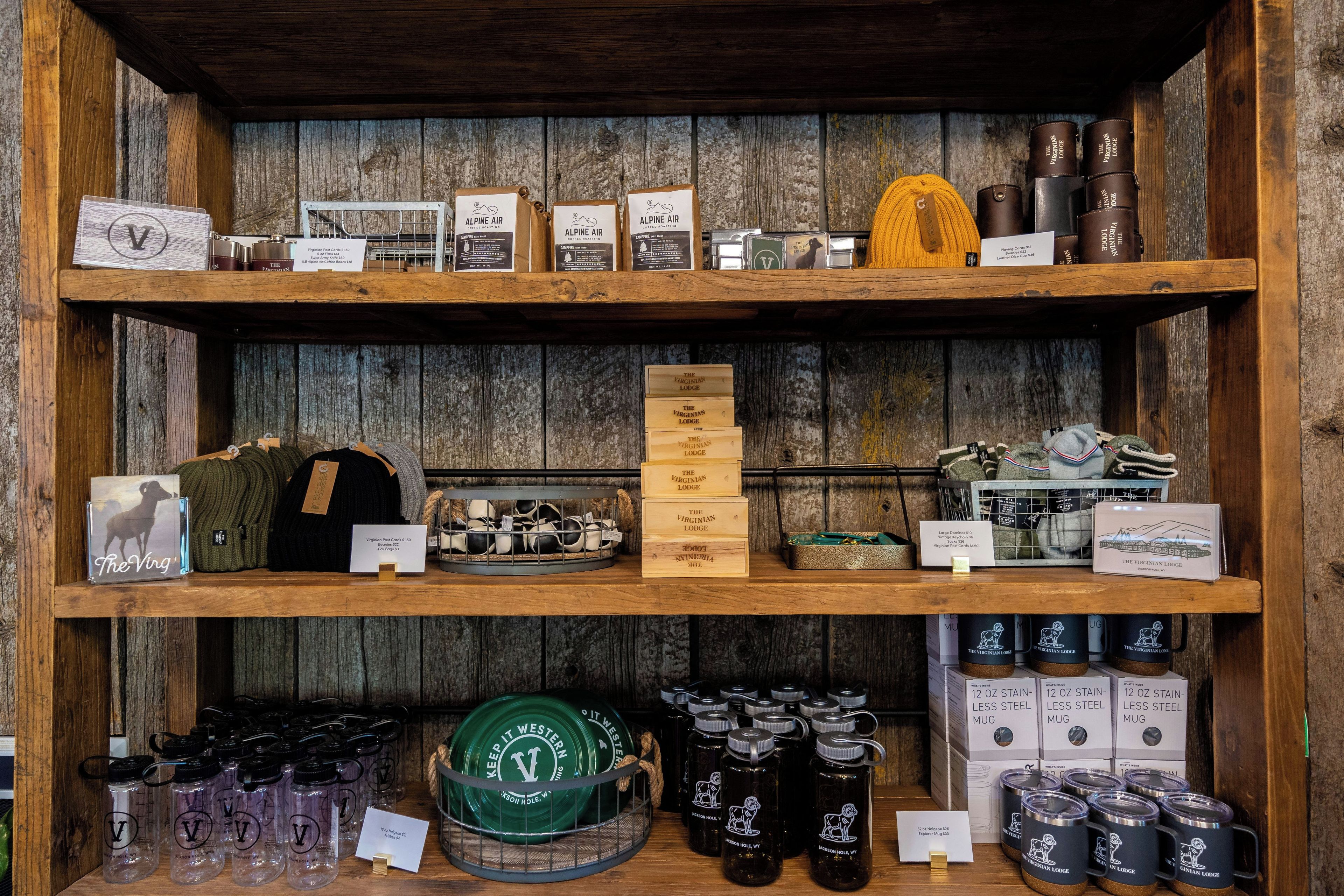 A wooden shelf with various items including coffee roasting bags, playing cards, and mugs.