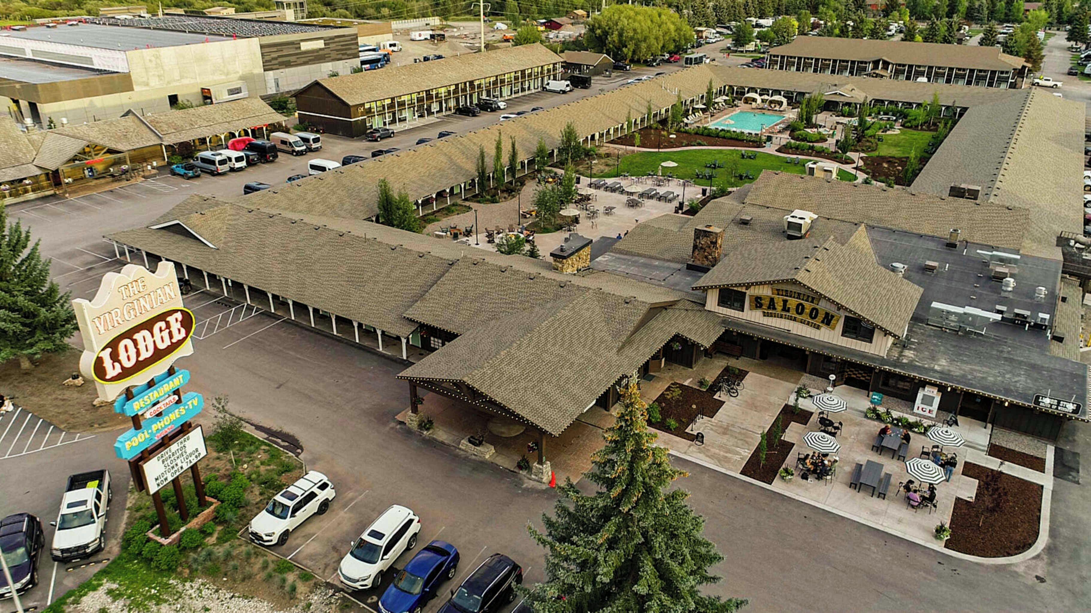 Een motel met een ruime parkeerplaats, een zwembad en een restaurant genaamd 'The Virginian Lodge'.